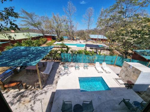an overhead view of a swimming pool with chairs and a swimming pool at Pinilla Highlands Incredible mountain views in Tamarindo