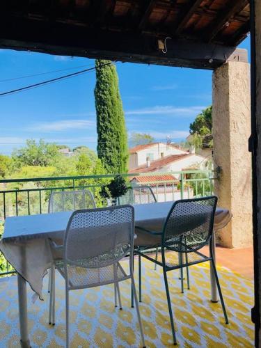 une table et deux chaises sur une terrasse dans l'établissement Lou Niú - le T3, à La Ciotat