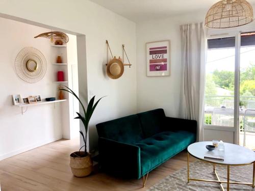 un salon avec un canapé vert et une table dans l'établissement Lou Niú - le T3, à La Ciotat