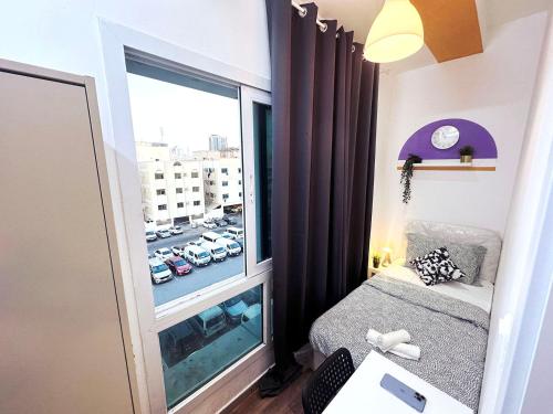 a small room with a bed and a large window at Partition Room In Al Seef Near Burjuman Metro in Dubai