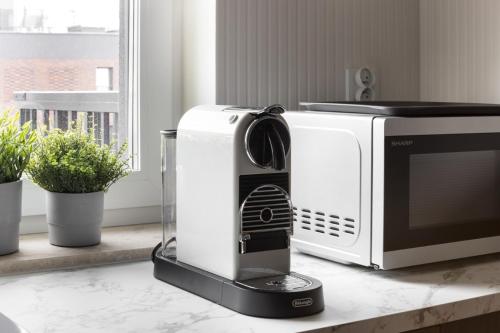 a microwave sitting on a counter next to a microwave oven at NEW #Madalińskiego57 - city center, new bulding, 2 bedrooms, 2x double beds and a fold-out sofa, separate kitchen, air conditioning, balcony, underground parking, self check in 24h, internet, Netflix, coffee machine, washing machine,1 km to the railway in Wrocław