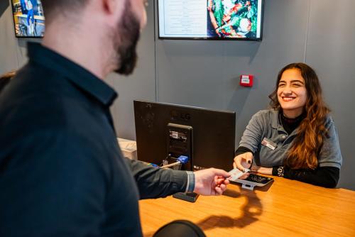 a woman sitting at a desk with a man and a woman sitting at a table at ibis Santo Andre in Santo André