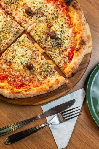 a pizza sitting on top of a wooden table at ibis Santo Andre in Santo André
