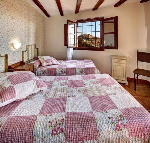 a bedroom with two beds and a window at Apartamentos Bellavista in Alquézar