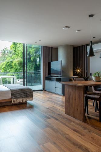 a bedroom with a bed and a table and a tv at Kiin Living- "Child-free coliving" in Medellín