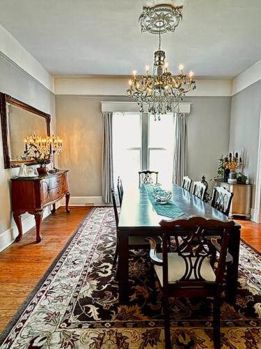 a dining room with a table and chairs and a chandelier at Viridia Bed and Breakfast in Littleton