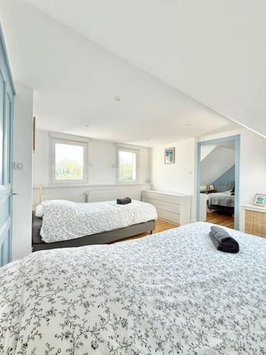 a bedroom with two beds and a mirror at Maison de vacances Audierne centre avec terrasse proche des plages in Audierne