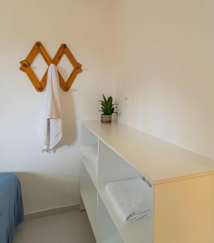a white kitchen with a white counter and a shelf at Chale 1 Prive Portal do Sol in Porto De Galinhas