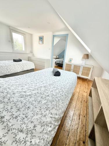 a white room with two beds and a staircase at Maison de vacances Audierne centre avec terrasse proche des plages in Audierne