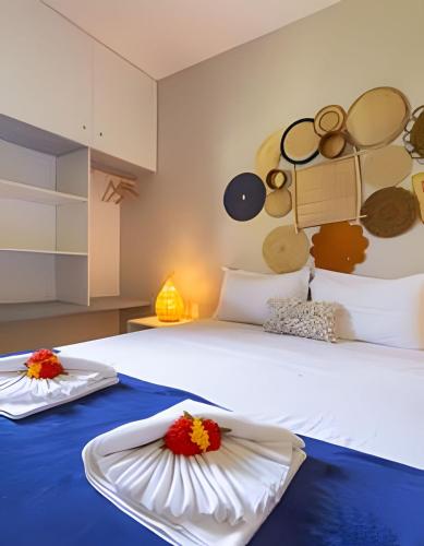a bedroom with a large white bed with flowers on it at Chale 1 Prive Portal do Sol in Porto De Galinhas