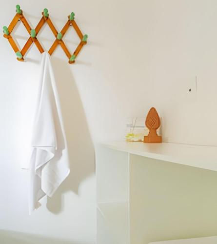 a white room with a shelf with towels on it at LC Casas de Praia - Chalé 3 centrinho de Porto in Porto De Galinhas