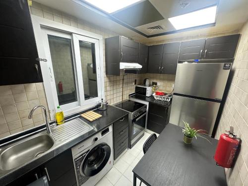 a small kitchen with a sink and a refrigerator at Cozy Corner Partition Room Near Burjuman Metro in Dubai