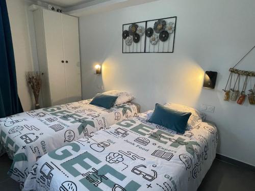 deux lits dans une chambre avec un couvre-lit et des oreillers dans l'établissement Paris studio, à Bagnolet