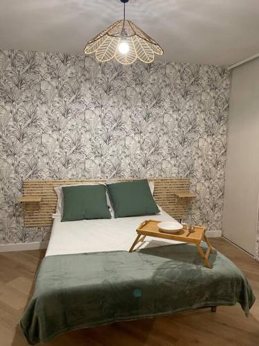 a bedroom with a bed with a table in it at Location T2 idéalement située in Bois de Nèfles