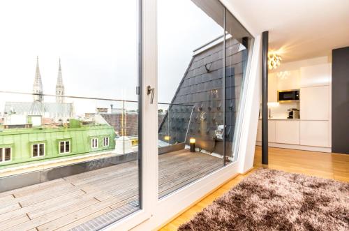 a room with a large window and a balcony at VotivPark Vienna Serviced Apartments in Vienna