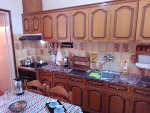 a kitchen with wooden cabinets and a sink at Giannis and Aristi's House in Kavala