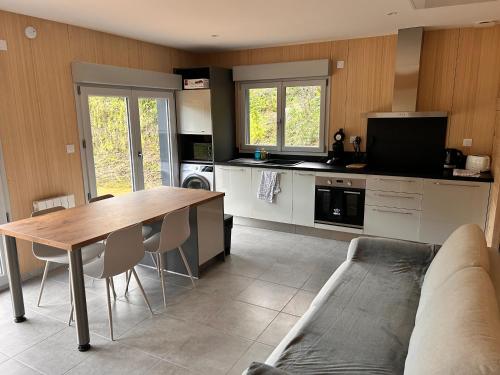 un salon avec une table et une cuisine dans l'établissement Les balcons de la vallée de la Marne PROCHE DISNEY À Azy Sur Marne, à Bonneil