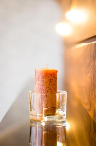 a candle in a glass jar on a table at VotivPark Vienna Serviced Apartments in Vienna