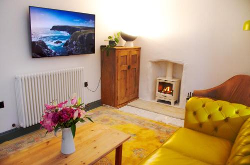 a living room with a couch and a fireplace at Wellington House Boutique Holiday Let in Falmouth
