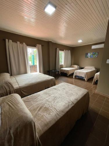 プエルトイグアスにあるHotel Don Raulのベッドルーム1室(ベッド3台付)