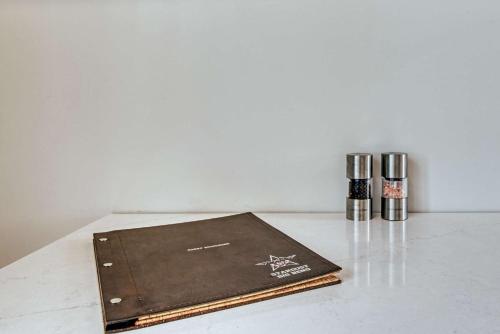 a brown notebook sitting on a table with two pens at Container Home at Stardust Big Bend 5 min from Park in Terlingua