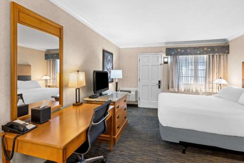 a hotel room with a desk and a bedroom with two beds at Best Western University Lodge in Davis