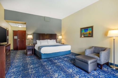 a hotel room with a bed and a chair at Best Western Plus Waynesboro in Waynesboro