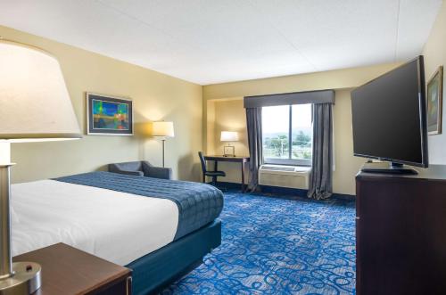 a hotel room with a bed and a flat screen tv at Best Western Plus Waynesboro in Waynesboro