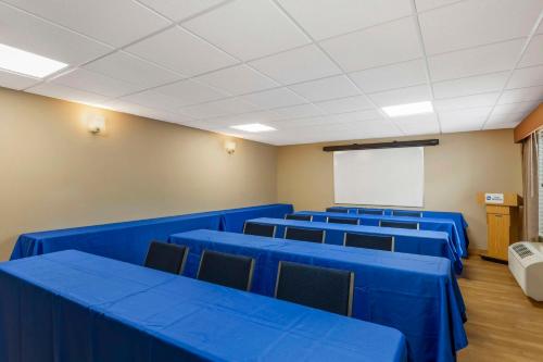 a conference room with blue tables and chairs and a white screen at Best Western Denver Southwest in Lakewood