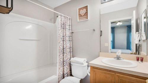 Un baño con lavabo, inodoro y ducha. en Family Friendly Townhome Near Attractions, en Orlando