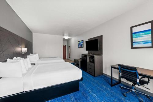 a hotel room with a bed and a desk and a tv at Best Western Palace Inn & Suites in Big Spring