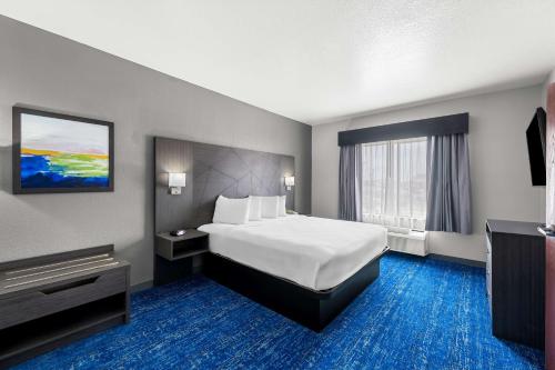 a hotel room with a bed and a television at Best Western Palace Inn & Suites in Big Spring