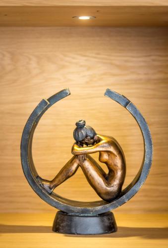 a bronze sculpture of a person with a bird sitting on their hands at VotivPark Vienna Serviced Apartments in Vienna