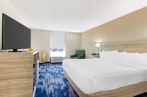 a hotel room with a large bed and a flat screen tv at Best Western Plus Beckley Inn in Beckley