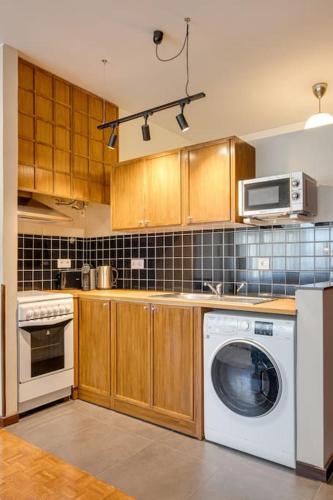 a kitchen with a washing machine and a microwave at Julio Dinis Studio in Porto