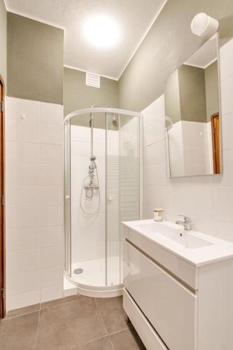 a white bathroom with a shower and a sink at Julio Dinis Studio in Porto
