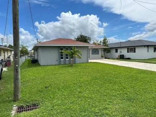 a white house with a palm tree in the yard at Cozy 2 BR Waterfront home with Heated Pool in Fort Myers