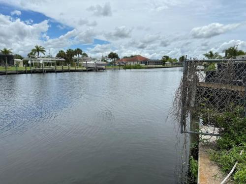 a large body of water with a dock and buildings at Cozy 2 BR Waterfront home with Heated Pool in Fort Myers