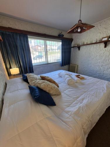 a large white bed with pillows on top of it at Departamento Completo Centro Bariloche in San Carlos de Bariloche