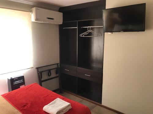 una camera da letto con un armadio nero e un letto rosso di Edificio Terravina a Tarija