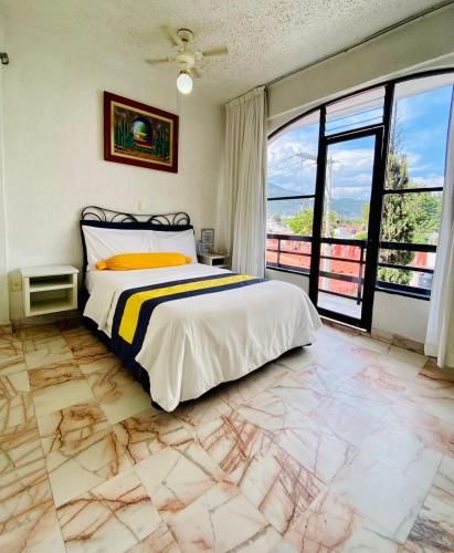 a bedroom with a bed and a large window at Hotel Presidente Vicente Guerrero in Chilpancingo de los Bravos