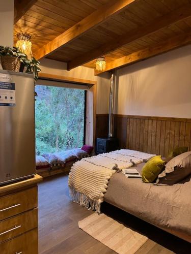 a bedroom with a bed and a large window at Wincarayen Lodge & Cabañas in Panguipulli