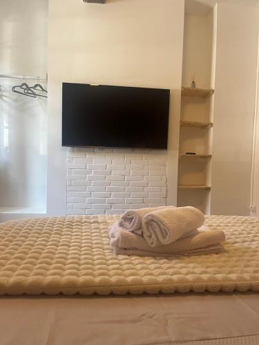 La salle de bains est pourvue d'un lit avec des serviettes et d'une télévision à écran plat. dans l'établissement La Fresque, T2 Moderne, Centre, à Arras