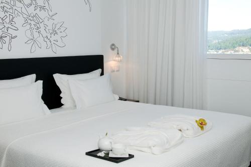 sypialnia z łóżkiem z ręcznikami w obiekcie Open Village Sports Hotel & Spa Club w mieście Guimarães