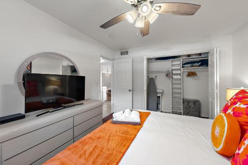 a bedroom with a large bed with a flat screen tv at Cocoa Beach Condo in Cocoa Beach