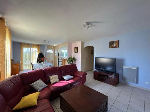 a living room with a couch and a flat screen tv at Maison accueillante à Gémozac - 100 m² avec jardin fertile. in Gémozac