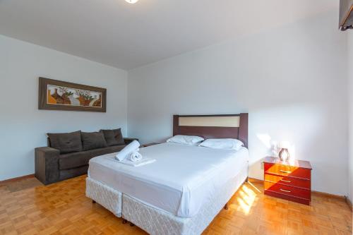 a bedroom with a bed and a couch at 3 Quartos na Mais Incrível Localização de Gramado in Gramado