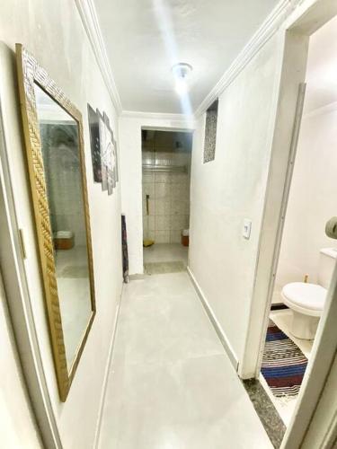 a hallway of a bathroom with a mirror and a sink at Porto Allegra in Cabo Frio
