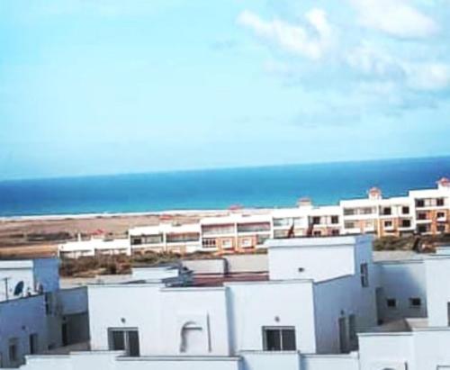 a group of white buildings with the ocean in the background at Charmant appartement á Tanger in Tangier