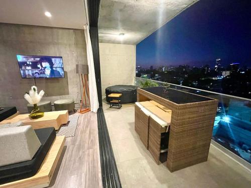 a living room with a view of a city at night at Espectacular diseño, terraza con Hamaca y Jacuzzi in Guadalajara